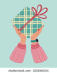 Gift box in hands. Present package wrapped in festive paper wrapping with tied bow, ribbon, twine string. Christmas, Xmas, valentine's day, birthday and New Year present in wrapping paper in hands.
