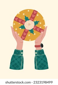 Gift box in hands. A gift wrapped in a festive paper wrapper with a tied bow, ribbon, twine, string. Christmas, Xmas, valentine's day, birthday and New Year present in wrapping paper in hands.
