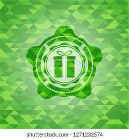 gift box icon inside green emblem with triangle mosaic background
