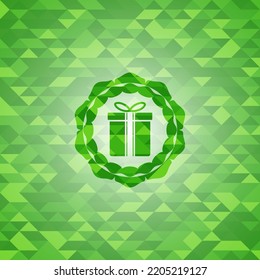 Geschenkbox-Symbol in grünem Mosaik-Emblem. 