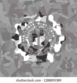 gift box icon inside grey camouflaged emblem