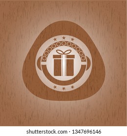 gift box icon inside wood badge or emblem