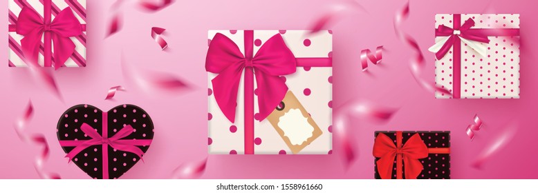 Gift box on pastel pink background with falling confetti.