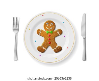Gingerbread man is on white plate with fork and knife, top view. Dinner plate with holiday cookie inside and cutlery set on sides
