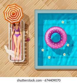 The girl in a bathing suit sunbathes. pool top view,  inflatable swim ring in shape of donut in the pool