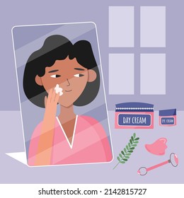 Girl in the bathroom takes care of the skin and applies a moisturizer to the face