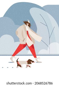 A girl in a beige hat, coat and scarf, in red pants walks near snowy winter part with a dog. A dog in a sweater and warm socks walks with the human, owner. Walking with pet outdoor in the cold season.