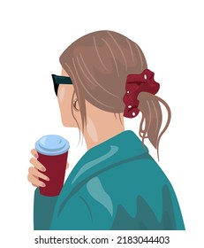 A girl in a birch coat with coffee with her hands. The hair is removed in the tail with a red hair elastic band. Suitable for the author of social networks.  a fashionable image for autumn