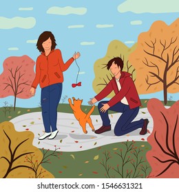 Girl and boy play with a cat in nature. Active lifestyle. Playing with the pet. Autumn landscape with road, colorful trees and fallen leaves.