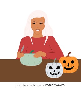 The girl carves a lantern from a pumpkin. Preparing for Halloween