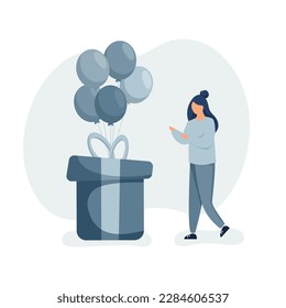 Girl celebrating birthday. Happy birthday party concept. Young woman standing near gift box with flying balloons. 