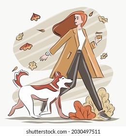 a girl with coffee in her hands walks with a dog in the park in autumn