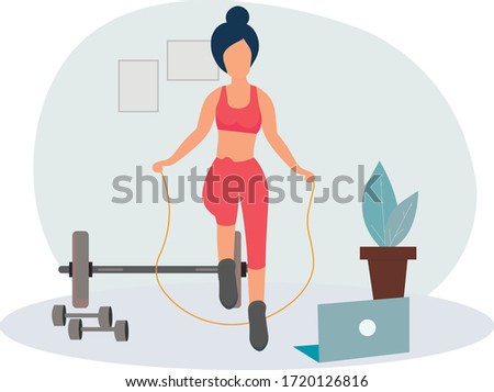 The girl does exercises, online training at home on a skipping rope . Stay at home. Sports online, fitness training. Healthy lifestyle. Keep yourself in shape. Quarantine isolation of the coronavirus.
