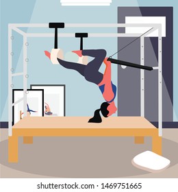 A girl doing pilates on a trapeze table