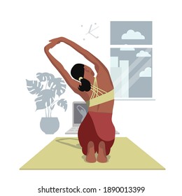 A girl doing yoga at home on a computer doing stretching online