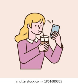 A girl is drinking a drink with a straw and looking at the phone. flat design style minimal vector illustration.