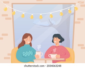 Girl friends sitting in cafe in winter day and drinking tea or coffee near large window. Cozy cafe with brick walls and lamps. Winter time and winter activity 
