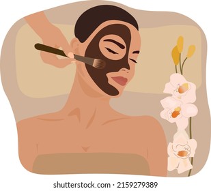 A girl gets a chocolate mask on her face. The concept of self-care in a spa salon.