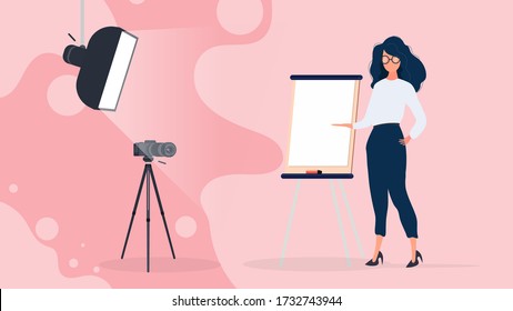 The girl is giving a presentation in front of the camera. The teacher conducts a lesson online. The concept of blogs, online training and conferences. Camera on a tripod, softbox.