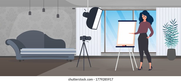 La chica está haciendo una presentación frente a la cámara. El profesor imparte una lección en línea. El concepto de blogs, capacitación en línea y conferencias. Cámara en un trípode, softbox.