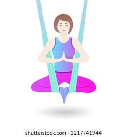 A girl hangs in a hammock in the lotus position. A woman practices asana from aerial yoga.