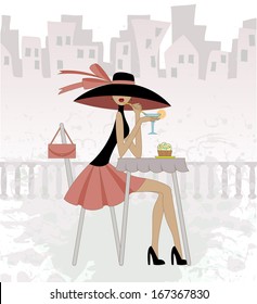 girl in a hat sits in cafe against the old city