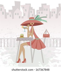 girl in a hat sits in cafe against the old city