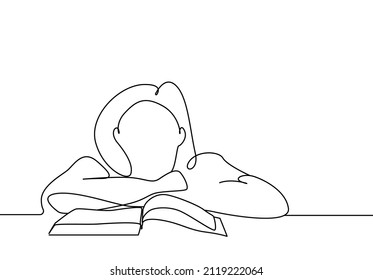 girl with her head on the table in front of the book thinks