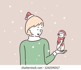 A girl holding a Christmas doll. hand drawn style vector design illustrations.