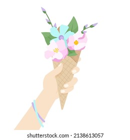 The girl holds in her hand a waffle ice cream cone with flower in it. 