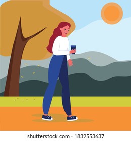 A girl with hot drinks in her hands is walking in an autumn Park