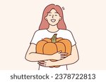 Girl hugs pumpkin and smiles widely, rejoicing at good harvest and opportunity to make jack-o-lantern for halloween holiday. Happy woman with pumpkin in hands laughing preparing for thanksgiving
