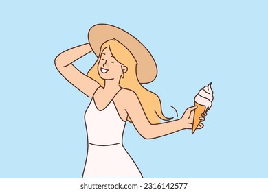 Girl with ice cream in waffle cone enjoys summer holidays and hot sunny weather. Happy young woman in summer dress and hat eats cold ice cream with creamy flavor to refresh herself after walk