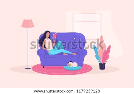 The girl laying on the sofa and reading some  book in her apartment