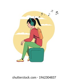 A girl listens to music on a park bench. Online radio. Outdoor recreation.