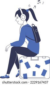 The girl listens to music while sitting on a suitcase. Travel waiting.