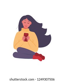 A girl with long hair is sitting with a smartphone in her hands. Vector illustration in flat style.