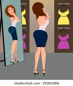 Girl looking in the mirror in the new dress in the fitting room