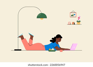 Girl lying on floor working on laptop indoor.