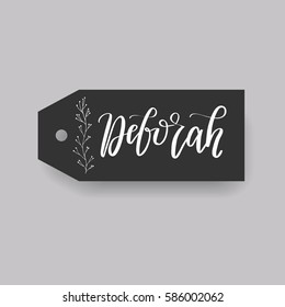 Girl name Deborah. Calligraphy lettering. Black badge decorated with botanical element and female name. Can be used as place card on wedding or anniversary.