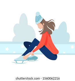 The girl on the rink puts on skates, winter fun and sports