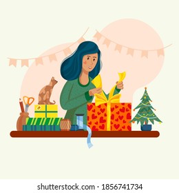 The girl is packing New Year's gifts. The cat is watching the hostess. On the table accessories for packing gifts.