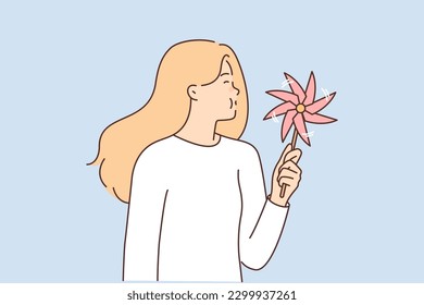 Girl with paper pinwheel in hands blows on toy spinning in wind. Child toy in hand of woman in white casual t-shirt using pinwheel to relieve stress or distract herself after hard day svg