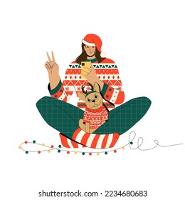 Girl with a pet dressed in knitted Christmas sweaters.