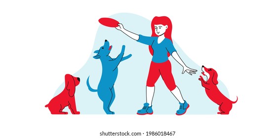 Girl playing with dogs in park. Woman throws flying disc and dogs jump and have fun
