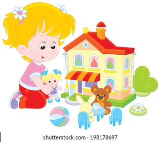 Girl playing with a doll and toy house