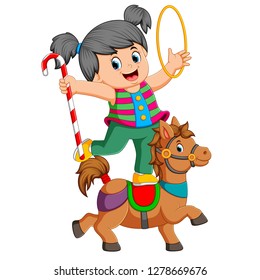 a girl is playing with the ring and candy stick on the circus horse