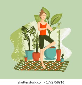 The girl is practicing yoga and meditation. The girl stands on one leg and meditates, surrounded by indoor plants, on a bright carpet. Spending time in self-isolation.
