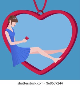 Girl reading a Valentine`s Day card sitting in heart-shaped pendant