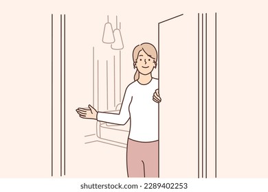 Girl realtor participates in showing apartment and calls to rent property or take mortgage. Hospitable woman opens door to apartment, invites guests to enter room and inspect interior